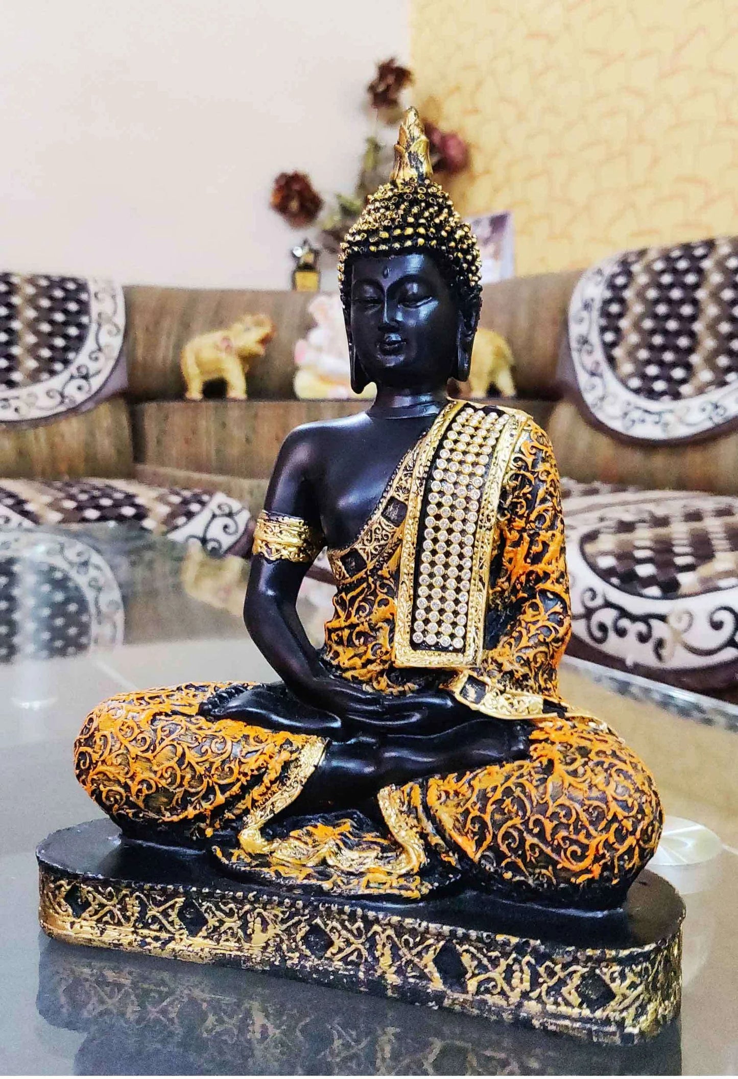 Resin Buddha statue in meditation posture with golden-orange robe and detailed base