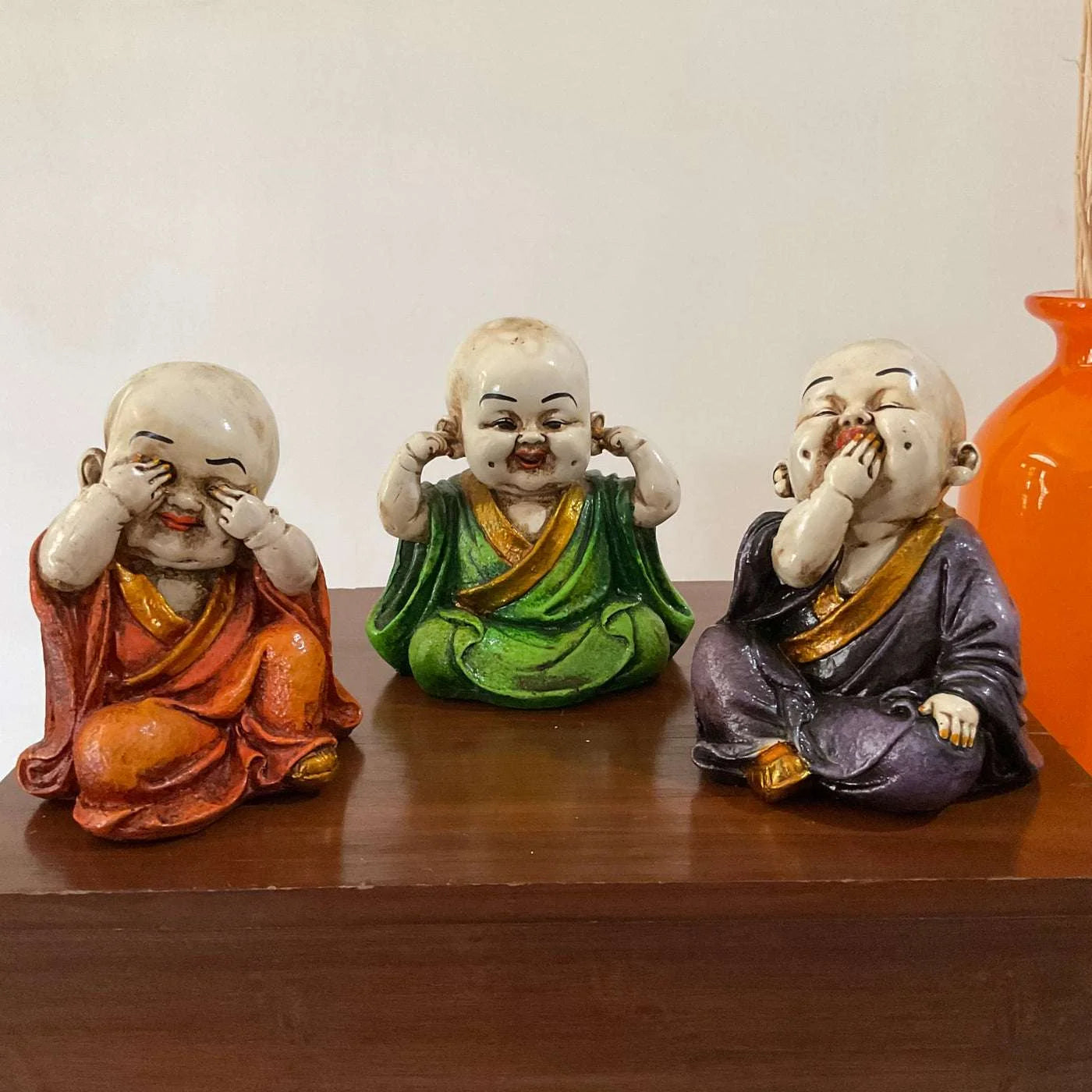 Set of three marble baby monk statues depicting see no evil, hear no evil, speak no evil concept in colorful robes