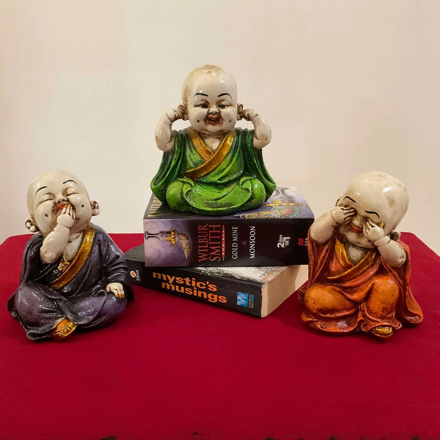 Set of three marble baby monk statues depicting see no evil, hear no evil, speak no evil concept in colorful robes