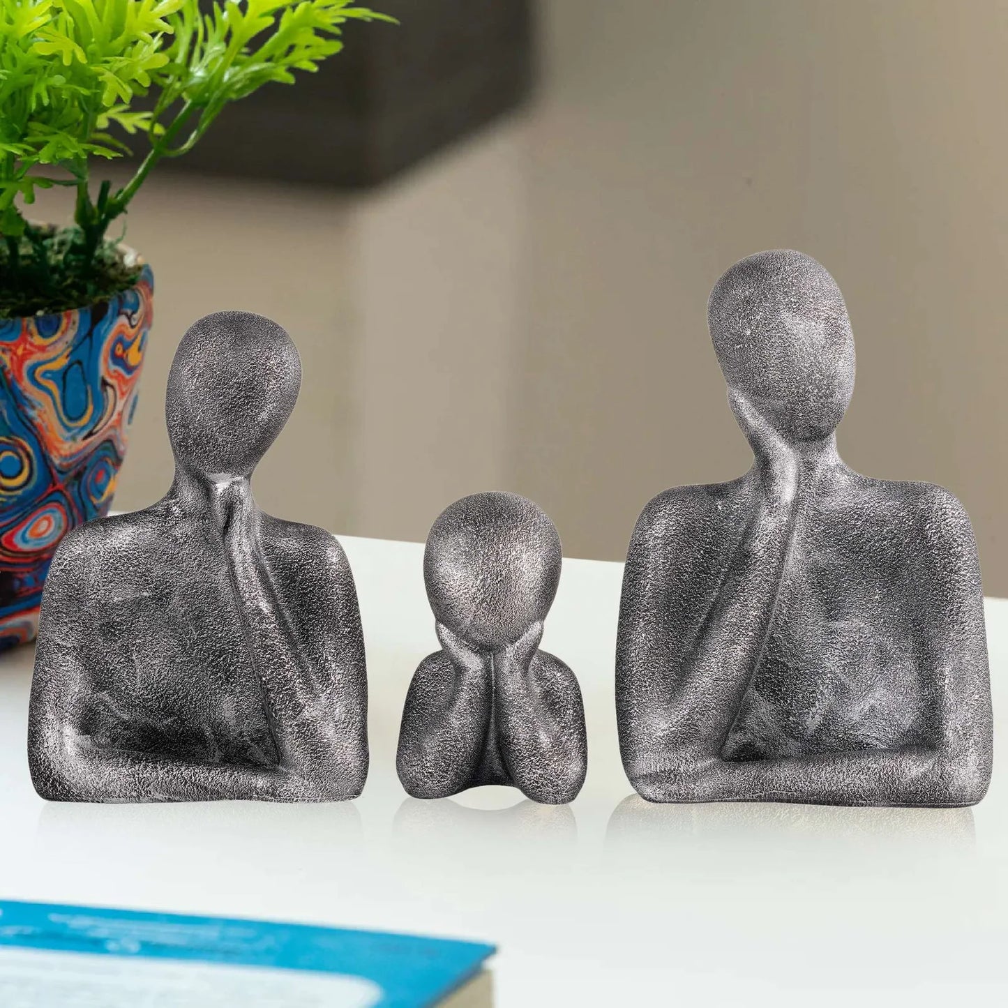 family sculpture set with faceless figures in a thinking pose